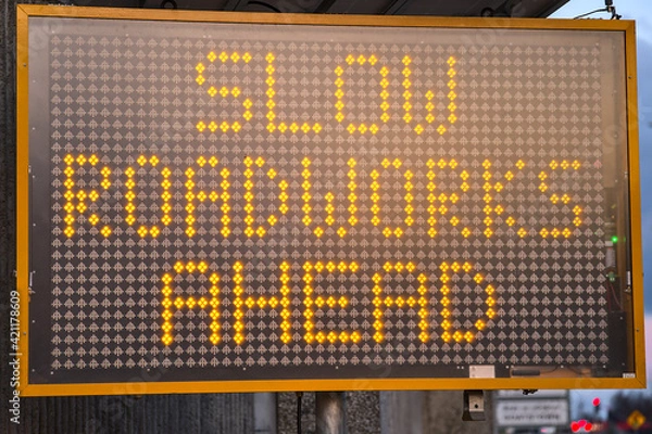 Fototapeta LED traffic control road sign solar powered message board mobile trailer variable message signs displaying Slow Roadworks Ahead along motorway in Dublin, Ireland