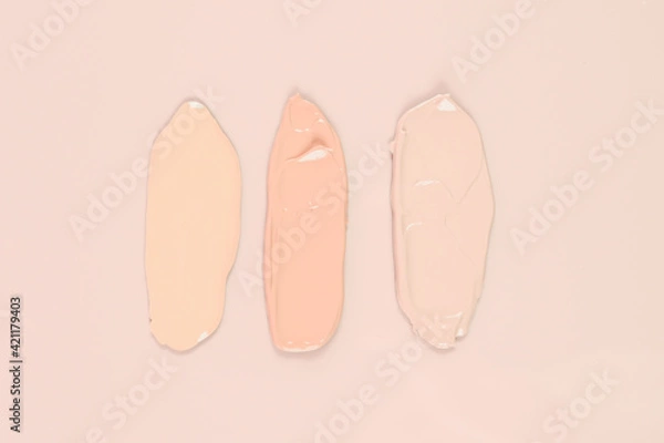 Fototapeta  Makeup product smears on pink background. Color set of foundation, top view