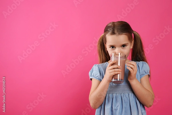 Fototapeta Cute little child drinking tasty chocolate milk on pink background, space for text