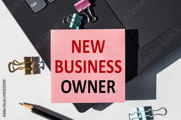 Fototapeta NEW BUSINESS OWNER note is written on a paper sticker on a laptop keyboard.