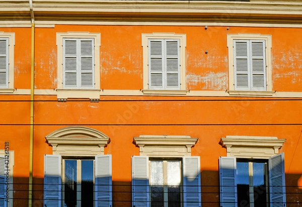 Fototapeta orange facade of the baroque building with blue windows and shutters. European architecture background