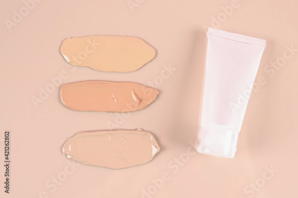 Fototapeta Makeup product smears on pink background. Color set of foundation, top view