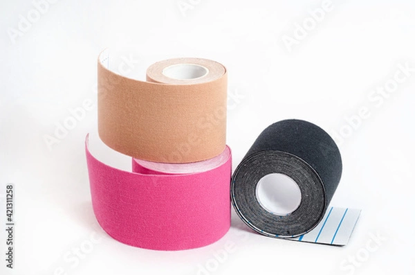 Fototapeta Kinesiological multi-colored tapes for fixing muscles during sports and after injuries on a white background.