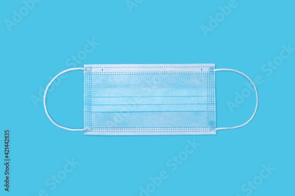 Obraz Medical protective mask on blue background. 