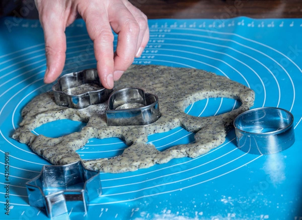 Fototapeta process of making cookies with poppy seeds: tin molds squeeze out the dough