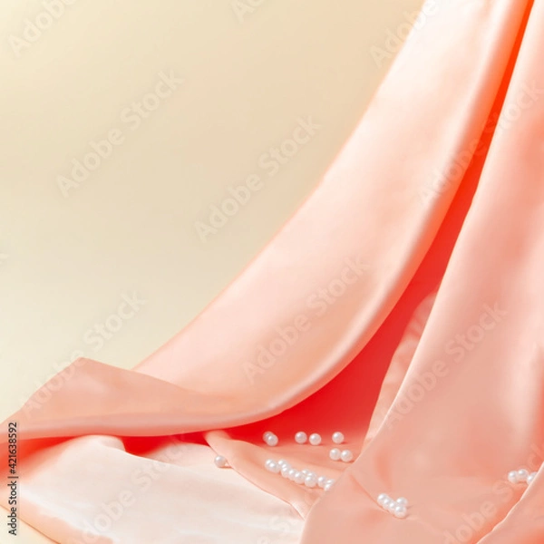 Fototapeta Smooth elegant silk or satin drape with white pearls on beige background. Luxury design. Minimal composition.