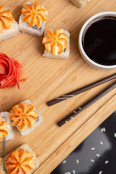Obraz Big sushi set on light wooden dish isolated on black background