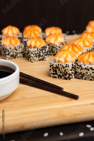 Obraz Big sushi set on light wooden dish isolated on black background