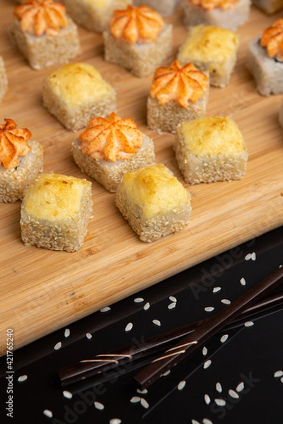 Obraz Big sushi set on light wooden dish isolated on black background