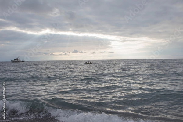 Fototapeta Fisherman boat on the sea so far for thire life with silhouette style background