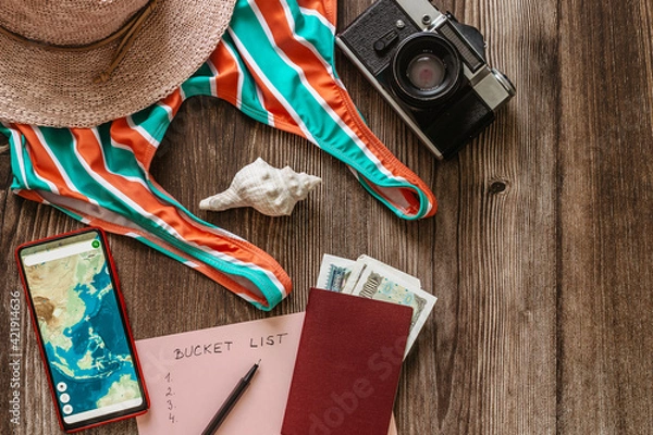 Obraz Travel concept banner flat lay.Items for summer vacation: passport,swimsuit,hat,money,smartphone with Asia map,retro camera copy space.Top view vacation concept.Planning fun trip.Travel accessories