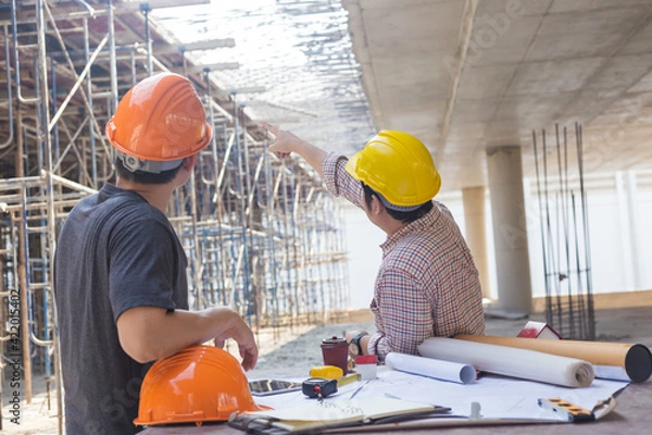 Fototapeta Three engineers working in a construction site