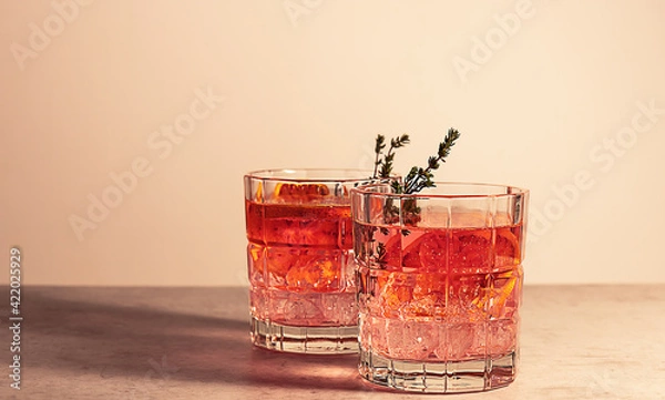 Fototapeta Pink gin cocktail with red blood orange and ice. An alcoholic, refreshing drink.