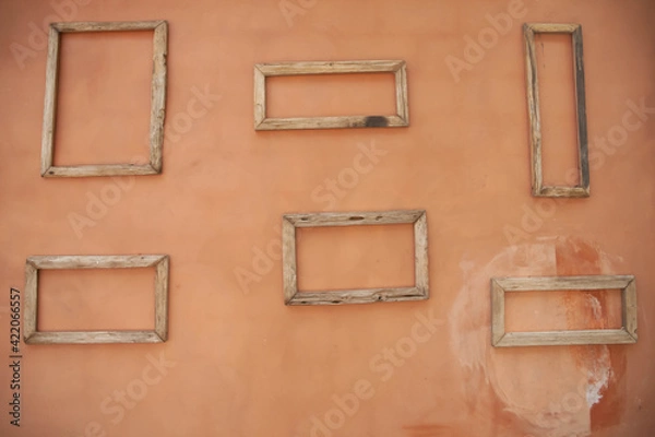 Obraz Wooden empty rectangle-shape frames on dirty orange wall.