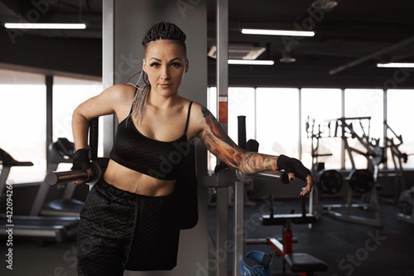 Fototapeta A disabled girl is engaged in the gym A woman with one leg trains with a trainer, she works hard and does not give up in front of trouble