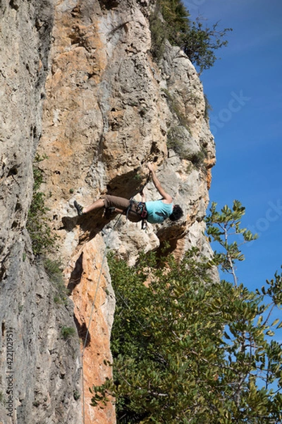 Obraz man climbing a mountain with rope