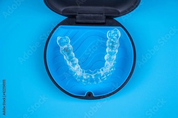 Obraz Invisalign transparent braces in a plastic case. Orthodontic invisible retainers and aligners