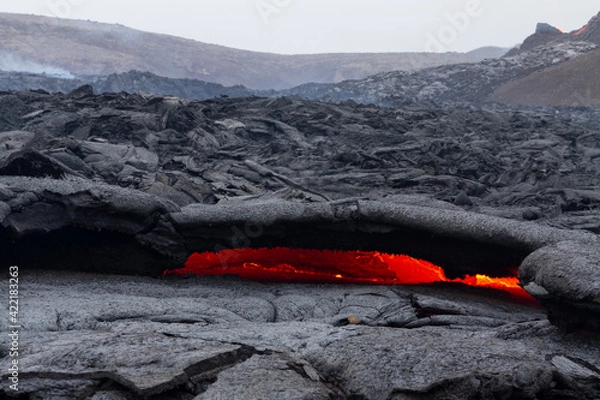 Fototapeta GELDINGADALIR, ICELAND - MARCH 21, 2021: A small volcanic eruption started at the Reykjanes peninsula. The event has attracted thousands of visitors who have braved a daring hike to the crater.