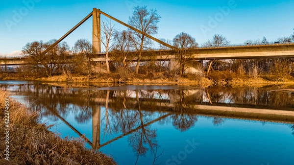 Fototapeta Beautiful autumn or indian summer view with reflections and a highway bridge near Mettenufer, Danube, Bavaria, Germany