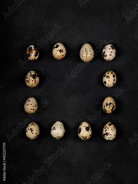 Fototapeta Geometric shapes from quail eggs on a black textured background. Square.