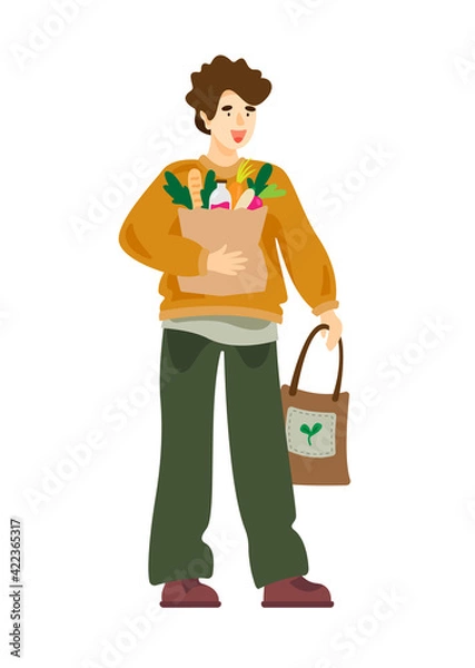 Obraz Young man holding a grocery paper bag and eco bag. Man with shopping bags. Zero waste, vegetarianism, ecology. No plastic bags. Eco bag with vegetables.