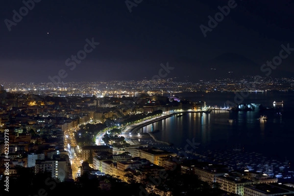 Obraz Panorama of the Gulf of Naples at night the metropolitan city with a thousand colors and reflections on the sea and in the background the stars and Vesuvius