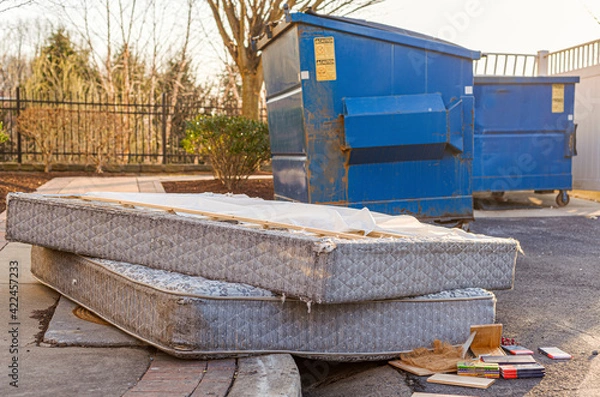 Fototapeta Despite regulations by the Home owners association, residents still illegally dump bulk items by the residential trash containers. Two old mattresses left behind by dumpster create unsightly look.