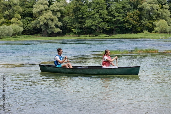 Fototapeta friends are canoeing in a wild river