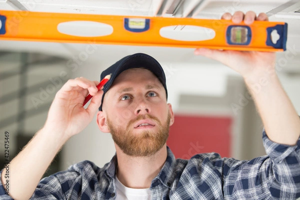 Fototapeta professional construction worker measuring ceiling