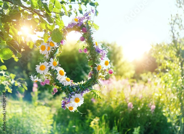 Fototapeta rustic wildflowers wreath on sunny meadow. Summer Solstice Day, Midsummer concept. floral traditional decor. pagan witch traditions, wiccan symbol and rituals