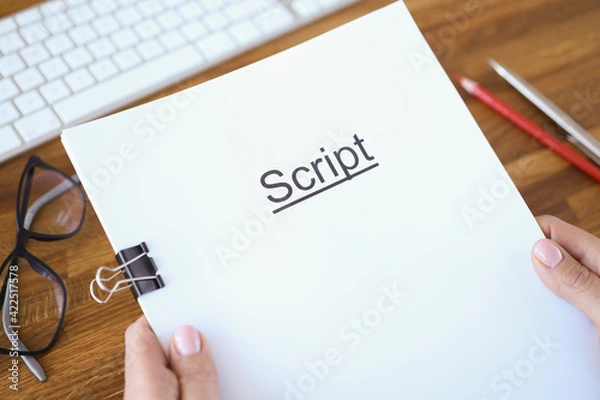Fototapeta Female hands holding script over table closeup