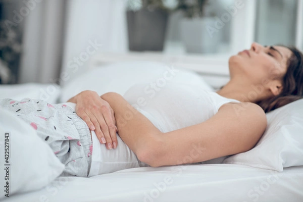 Obraz Sad lying womans hands touching belly