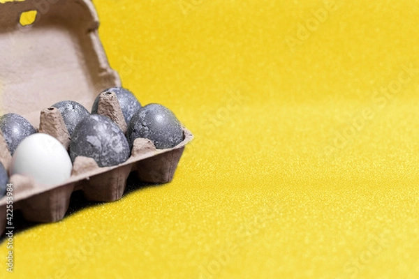 Obraz Eggs with marble stone effect painted with natural dye carcade flower on yellow sparkling background