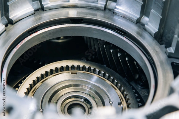 Fototapeta Set of various engine and gearbox spare parts. Shiny gears for planetary gearbox.Metal autotechnology background. wheel engine gears, close up. Automatic transmission in section