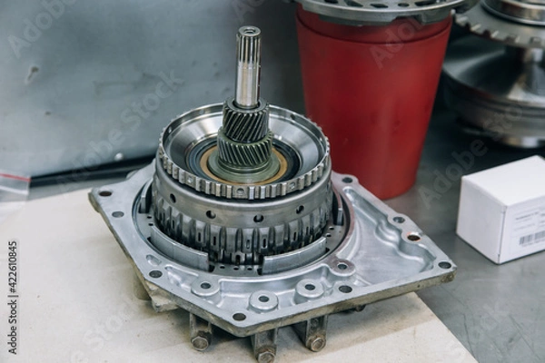 Fototapeta Set of various engine and gearbox spare parts. Shiny gears for planetary gearbox.Metal autotechnology background. wheel engine gears, close up. Automatic transmission in section