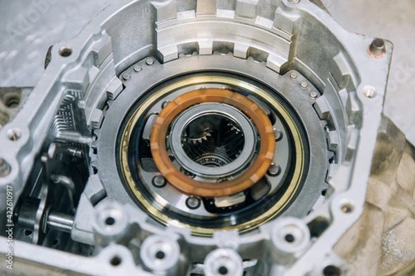 Fototapeta Set of various engine and gearbox spare parts. Shiny gears for planetary gearbox.Metal autotechnology background. wheel engine gears, close up. Automatic transmission in section