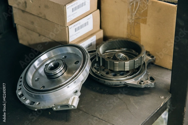 Fototapeta Set of various engine and gearbox spare parts. Shiny gears for planetary gearbox.Metal autotechnology background. wheel engine gears, close up. Automatic transmission in section