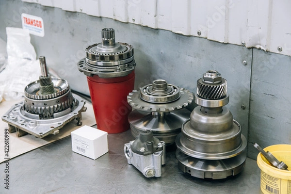 Fototapeta Set of various engine and gearbox spare parts. Shiny gears for planetary gearbox.Metal autotechnology background. wheel engine gears, close up. Automatic transmission in section