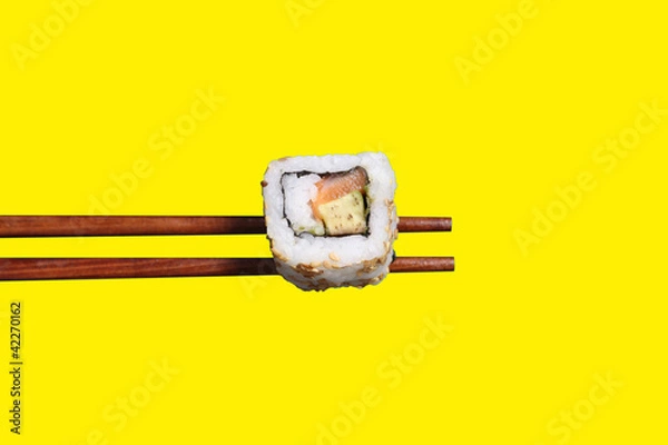 Fototapeta Californian roll on chopsticks
