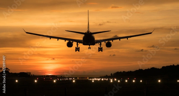 Fototapeta Silhouette Airplane will take-off at an airport during sunset sky