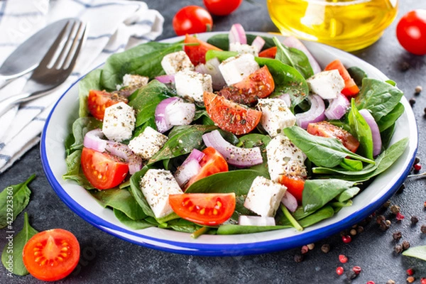 Obraz Healthy food. Greek salad with spinach, tomato, sweet pepper, red onion, feta cheese on a dark background