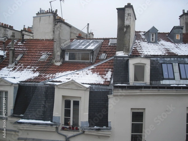 Obraz Toits de Paris en tuiles et zinc, partiellement enneigés, avec cheminées, combles, fenêtres et lucarnes