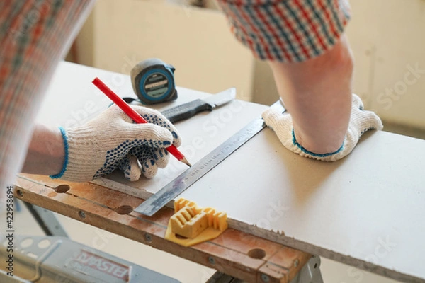 Obraz Builder measures and marks drywall sheet