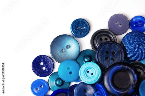 Fototapeta Colorful blue buttons on a white background. Lots of blue buttons. Old vintage buttons close up. Copy space. Top view. Background of buttons. Flat lay.