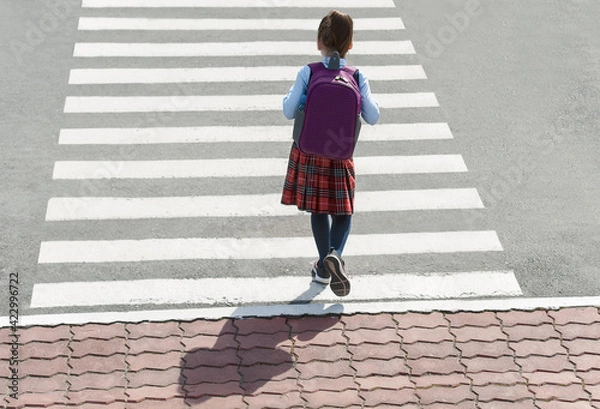Obraz Stylish young teen girl walking with backpack. Active child. Kid runs across the crosswalk. Way forward. Direction to success. Positive thinking. Symbol of overcome obstacles and challenge. Top view