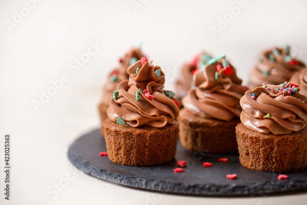 Fototapeta chocolate cupcakes with chocolate cream cheese on a light background.