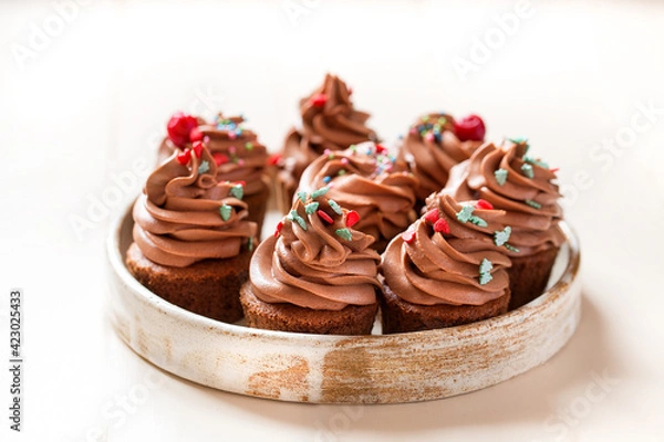 Fototapeta chocolate cupcakes with chocolate cream cheese on a light background.