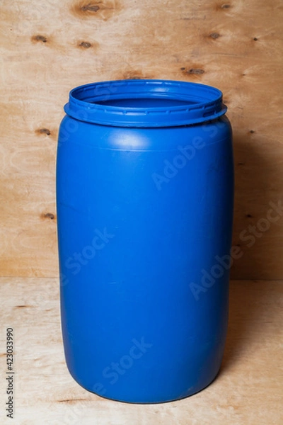 Fototapeta Plastic barrel stands on wooden background