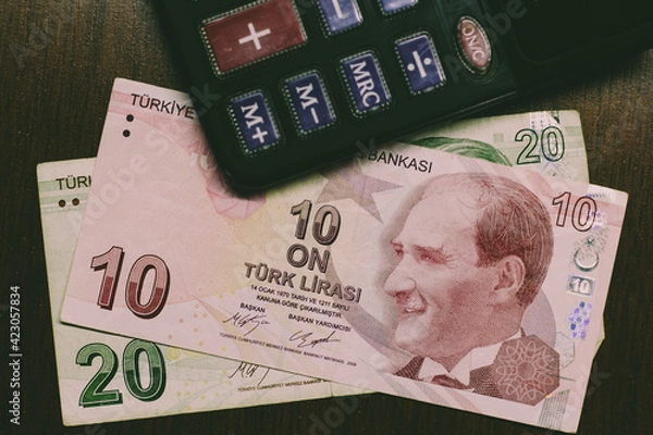 Obraz Turkish lira bills with a calculator on a wooden desk