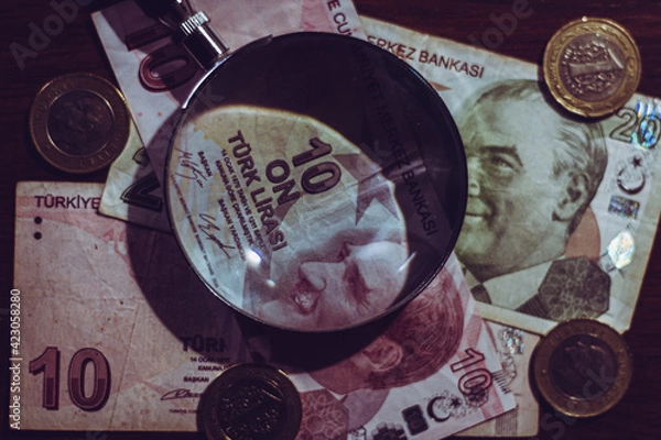 Obraz Turkish lira bills seen through a magnifying glass and coins
